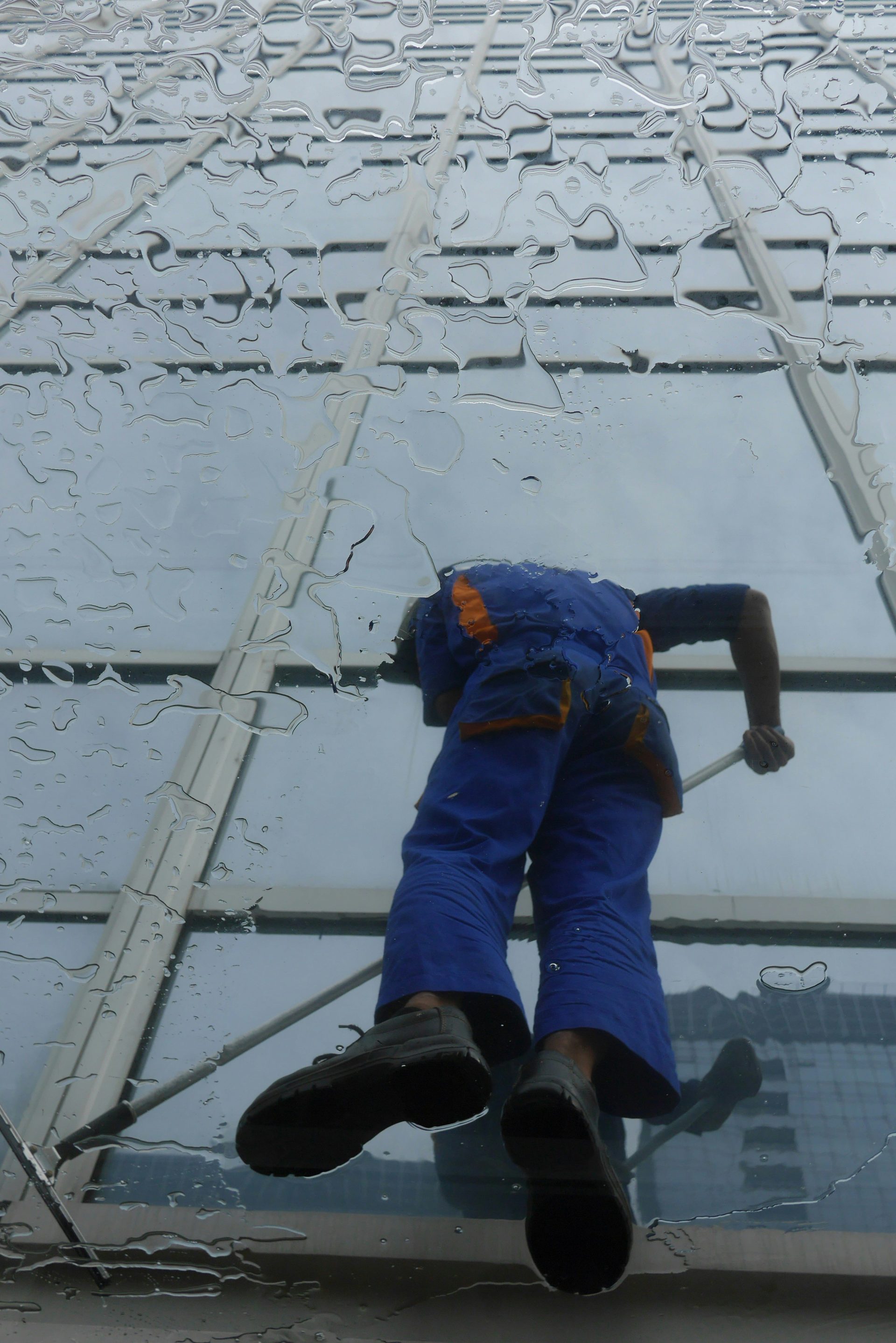 Fensterputzer bei der Arbeit an der Glasfassade eines Gebäudes